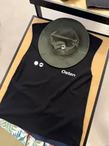 Musculosa negra sin mangas con estampado gráfico en la espalda que incluye un sol estilizado en blanco y el texto "Osten Empower Elevate Your Strenght".