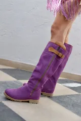 Botas altas de gamuza color rojo con forro de cuero, cierre lateral y suela de goma.