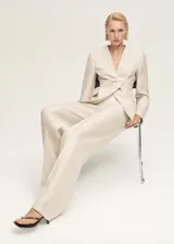 Pantalón de vestir color beige, de corte recto y tiro medio.