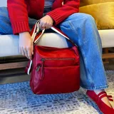 Bandolera marrón de cuero sintético con correa larga regulable combinada a tono. Tiene dos bolsillos frontales con cierre, apertura superior con cierre, división interna, bolsillos internos y bolsillo trasero con cierre.