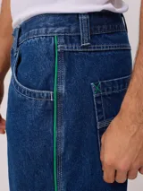 Bermuda de jean celeste con detalle de una línea vertical naranja en los laterales.