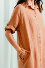 Vestido camisero largo color ocre, de lino, con cuello camisero, abotonado al frente y mangas 3/4 con trabilla.