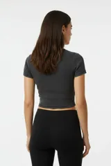 Remera de manga corta, corte ajustado al cuerpo, color malva o rosado oscuro, confeccionada en tejido acanalado. Presenta un estampado frontal de estrella con efecto brillante o metalizado.