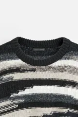 Jersey de hombre con corte relaxed, cuello redondo y manga larga. Diseño con patrón geométrico jacquard en tonos negro, gris y blanco.
