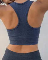 Top deportivo azul jaspeado, sin relleno (push up), con breteles anchos y banda inferior elástica.