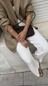 Brazalete rígido dorado con textura irregular.