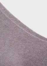 Sweater lila de punto con cuello asimétrico y manga larga.