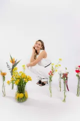 Conjunto blanco compuesto por un top sin mangas con diseño cruzado en el frente y un pantalón de vestir de corte recto. Incluye cinturón fino negro con hebilla dorada.