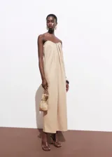 Vestido largo color beige, sin mangas y con escote corazón.