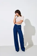 Pantalón de jean azul oscuro, de corte ancho, tiro alto y cierre de botones.