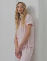 Conjunto de pijama marca Pillow Talk, compuesto por camisa de mangas cortas con solapa y bolsillo, y pantalón largo con cintura elastizada y lazo de ajuste. Diseño a rayas verticales rosas y blancas.