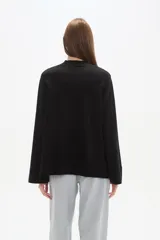 Sweater de viscosa color beige, con cuello polera, corte holgado y pespuntes decorativos en el frente.