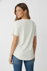 Remera negra de algodón con estampado de un corazón con palmeras, estrellas y flores.