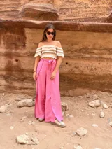Pantalón fucsia de tiro alto, corte palazzo y aberturas laterales en el ruedo.