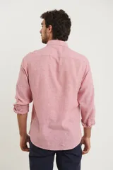 Camisa azul marino de lino y algodón, con cuello abotonado, manga larga con puños enrollados, bolsillo de parche en el pecho y cierre frontal con botones.