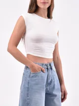 Remera blanca de corte crop top, con mangas cortas y cuello redondo.