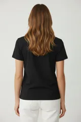 Remera de algodón color beige, manga corta y cuello redondo, con estampado frontal de una flor azul y texto en foil dorado que dice "You are Unique".