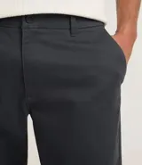 Pantalón de hombre de sarga color gris oscuro, de corte recto, con cintura con trabilla, cierre tradicional y bolsillos.