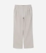 Pantalón wide leg color gris claro, con bolsillos laterales, cierre con gancho y cremallera, y pliegues dobles delanteros.