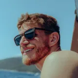 Lentes de sol con montura de madera color marrón con estampado de vetas y lentes grises.