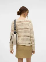Sweater de punto calado color crema, con cuello redondo y mangas largas. Diseño holgado y tejido liviano.
