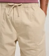 Bermuda masculina color beige confeccionada en sarga de algodón, con cintura elástica, cordón ajustable y bolsillos laterales.