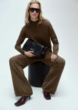 Jersey negro de punto fino con cuello alto, diseño oversize y manga larga.