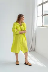 Vestido camisero color verde lima de lino, con cuello clásico, cierre frontal con botones y mangas largas con puños abotonados.