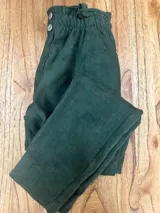 Pantalón de gamuza azul con elástico en la cintura, dos botones decorativos y bolsillos funcionales en la delantera.