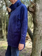 Polerón azul de plush de algodón con cuello alto, mangas largas y corte holgado. Cuenta con tajos laterales y espalda más larga. Tiene aperturas laterales ocultas para amamantar.