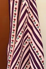 Camisa de manga larga con estampado de rayas verticales verdes y blancas con flores rojas.