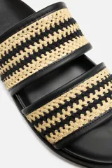 Sandalias negras con dos tiras trenzadas en color beige.