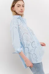Camisa celeste de algodón con bordado calado tipo broderie, manga larga con puño angosto y botones al frente.