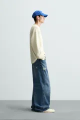 Jersey color crudo de algodón con textura, corte relaxed fit, cuello redondo y manga larga. Acabados en rib con detalle de vuelta.