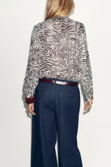 Blusa de manga larga con estampado animal, cuello redondo con lazada y escote pico.