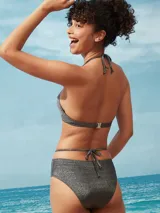 Conjunto de bikini negro brillante con corpiño triangular con tirantes finos y bombacha de corte clásico con tiras laterales.