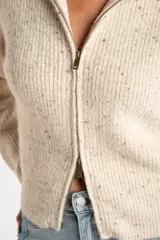 Cardigan de punto color beige melange con textura tweed, cuello alto y cierre frontal metálico. Corte ajustado al cuerpo y manga larga.