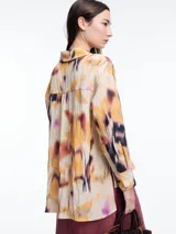 Camisa de manga larga confeccionada en viscosa crinkled con estampa de manchas. De silueta amplia y fluida, con bolsillos frontales grandes, tajos laterales y largo extendido en la espalda.