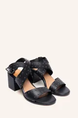 Sandalia de cuero vacuno negra con tiras cruzadas y tachas metálicas. Taco ancho de 6,5 cm.