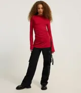 Blusa femenina ajustada, confeccionada en malla rib de viscosa, con cuello alto y mangas largas. Sin estampa y posee fruncido en los laterales.