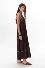 Vestido largo color crudo con breteles finos y costuras a la vista en color azul.