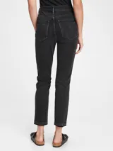 Pantalón de jean negro con tiro alto, corte slim y terminación desflecada.