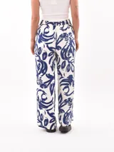 Pantalón palazzo con estampado de hojas y flores en tonos azul y blanco.