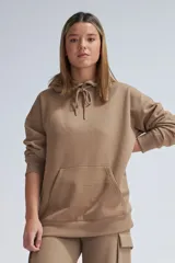 Hoodie deportivo color visón, de corte holgado, con capucha ajustable con cordones, bolsillo tipo canguro y puños y bajo acanalados.
