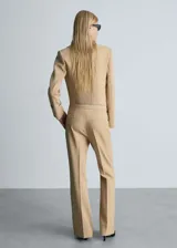 Pantalón de vestir color beige, de tiro medio y corte acampanado.