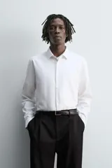 Camisa blanca de manga larga, corte slim fit, con cuello italiano y cierre frontal de botonadura.