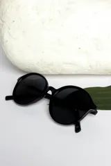 Lentes de sol redondos color negro con montura de pasta y cristales polarizados.