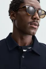 Polo de piqué color crudo, corte regular fit, cuello solapa con cierre de botonadura y mangas cortas.