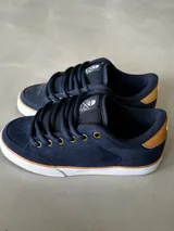 Championes de skate Circa AL 50, color azul marino con detalles en marrón y blanco. Confeccionados en gamuza con puntera de triple costura, lengüeta acolchada con logo y ojales metálicos. Suela vulcanizada.