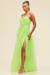 Vestido largo de fiesta color verde lima, confeccionado en organza. Presenta escote corazón, corte a la cintura y falda con abertura lateral.